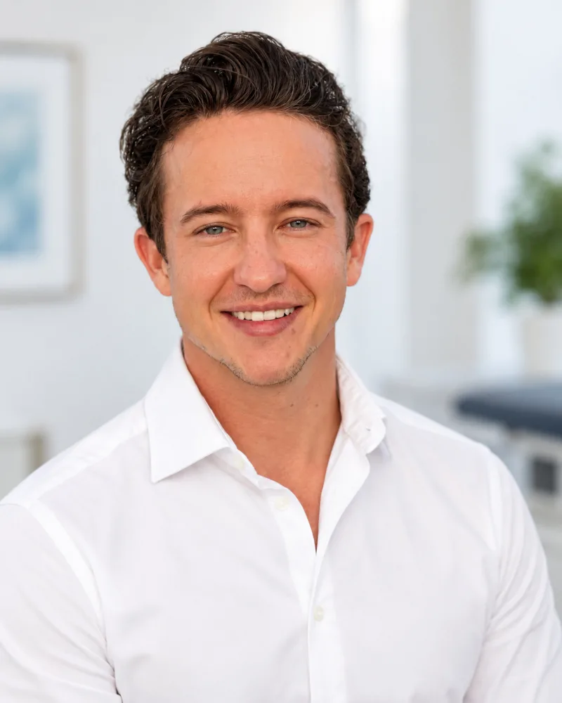 Dr. med. Joel Baur, Facharzt für Ophthalmologie FMH, im weissen Arztkittel